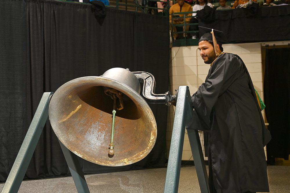 Jayesh Jain ringing the victory bell at graduate students' commencement winter 2023