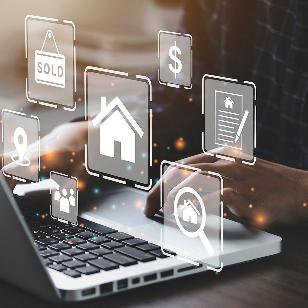 Undergraduate programs in finance, real estate concentration. Person sitting at a laptop with icons representing real estate finance popping up in front of their hands.