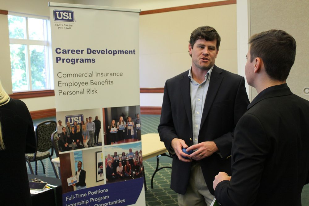 Student at a career fair speaking with a representative from USI Insurance Services